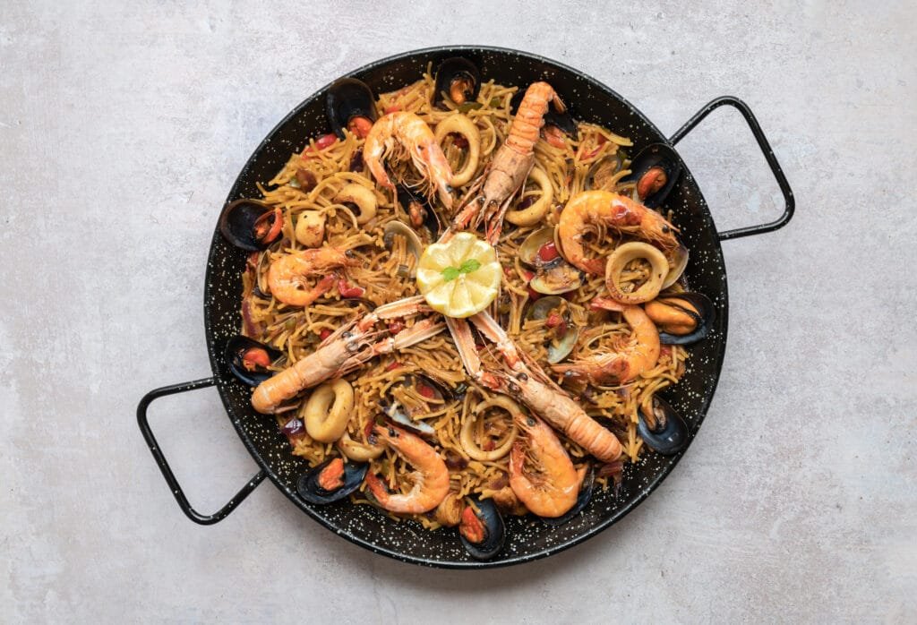 Top view shot of delicious Paella with seafood and onion rings Lissabon Paella